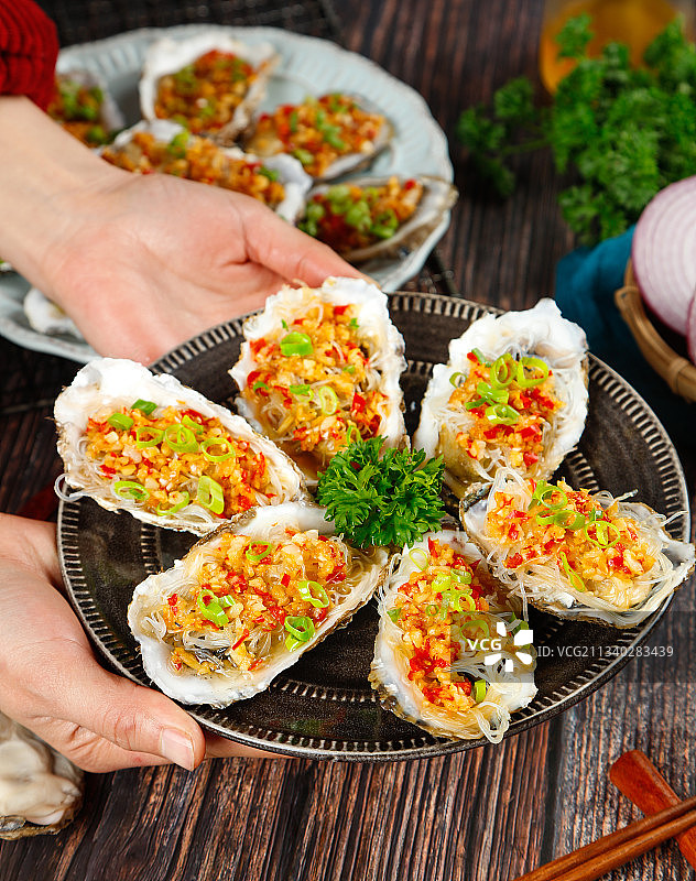 手端一盘香辣粉丝生蚝图片素材