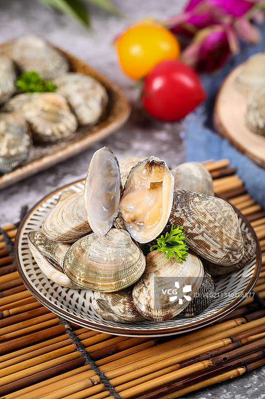 木排上放着一盘张开的花蛤图片素材