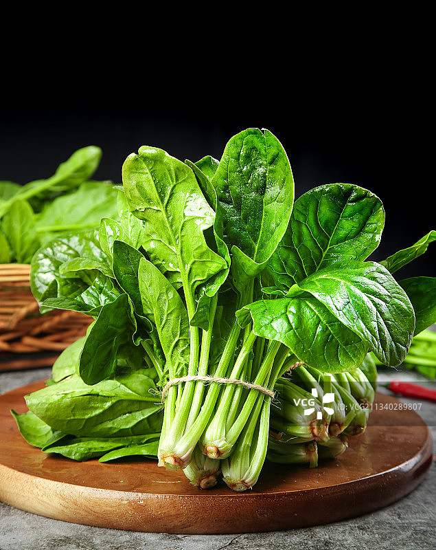 木板上放着绿色菠菜图片素材