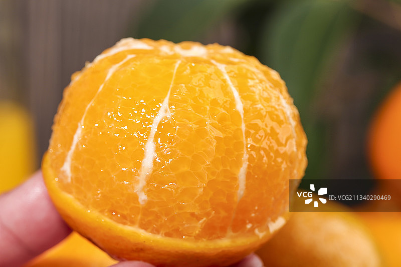 手拿削皮的皇帝柑图片素材