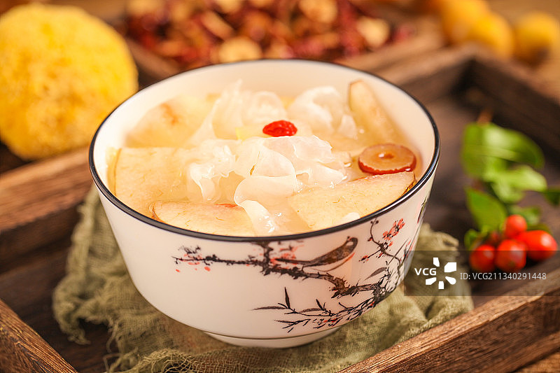 一碗银耳雪梨汤放在木底上图片素材