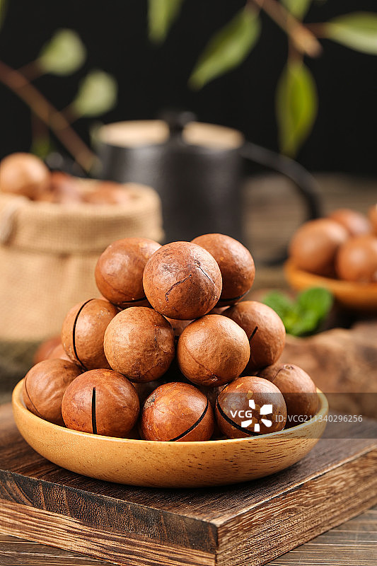 一碟夏威夷果放在木底上图片素材