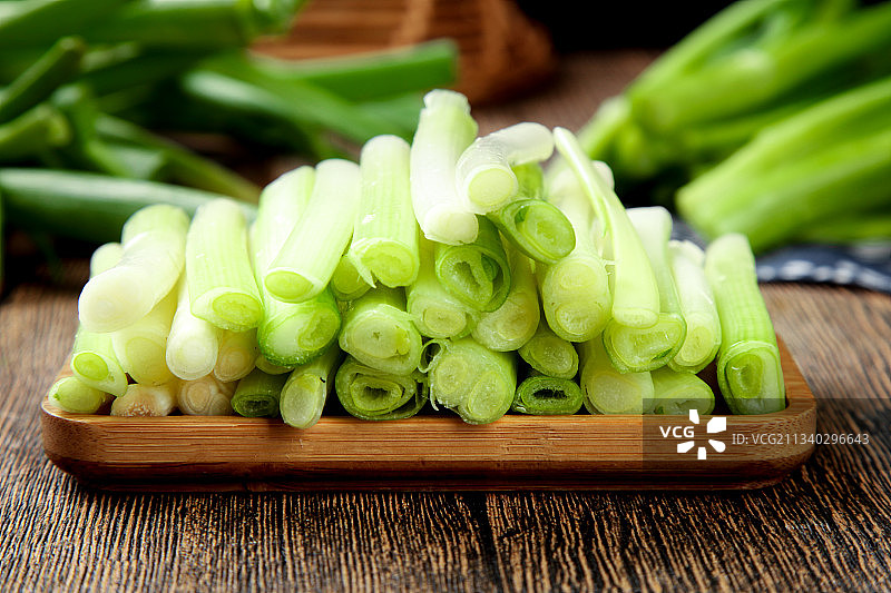 一盘切开的葱白放在木底上图片素材