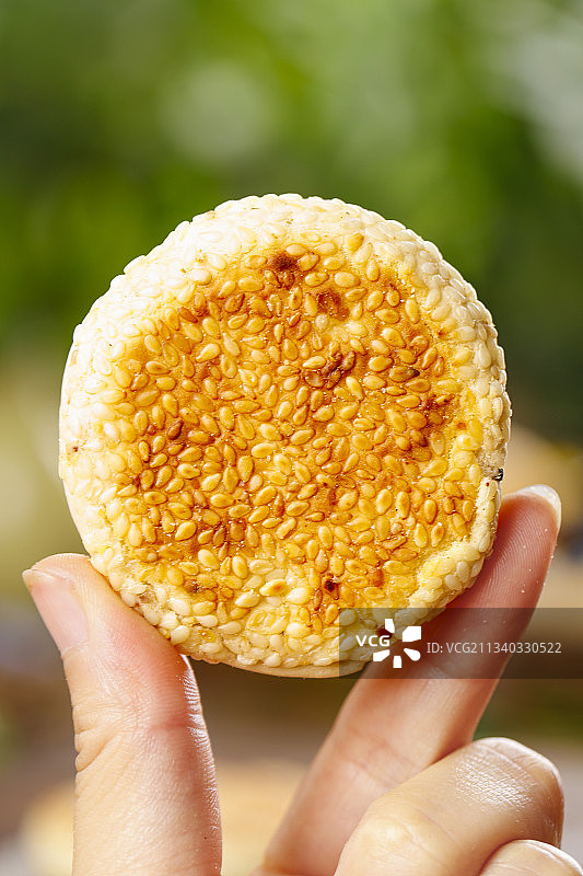 手里拿着手工芝麻饼图片素材