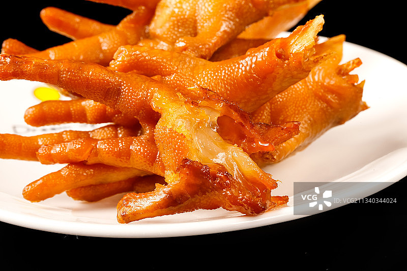 黑底上放着一盘卤鸡脚图片素材