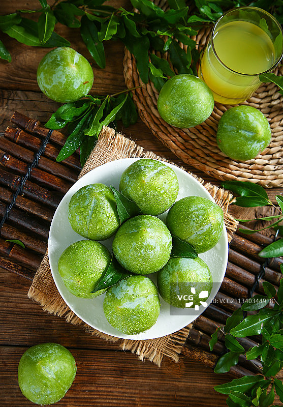 木底上放着一盘奈李图片素材