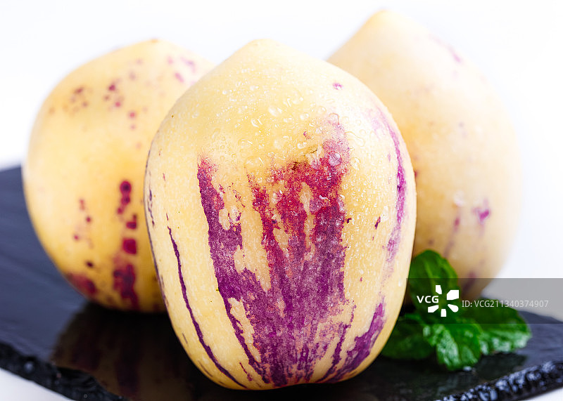 黑石板上放着新鲜人参果图片素材