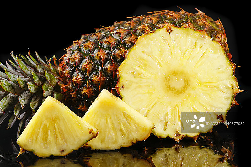 黑底上放着切开的金钻凤梨图片素材