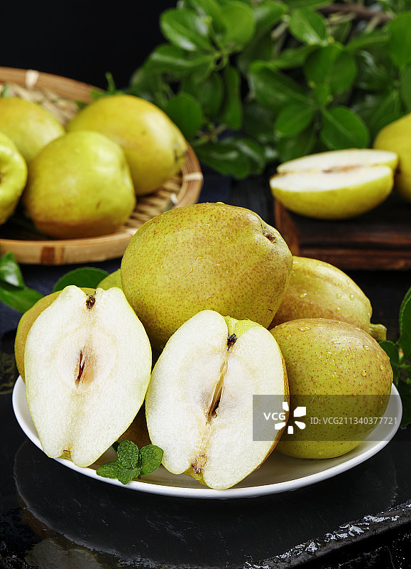 石板上放着一盘切开的小香梨图片素材