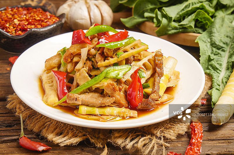 木底上放着一盘竹笋炒肉图片素材