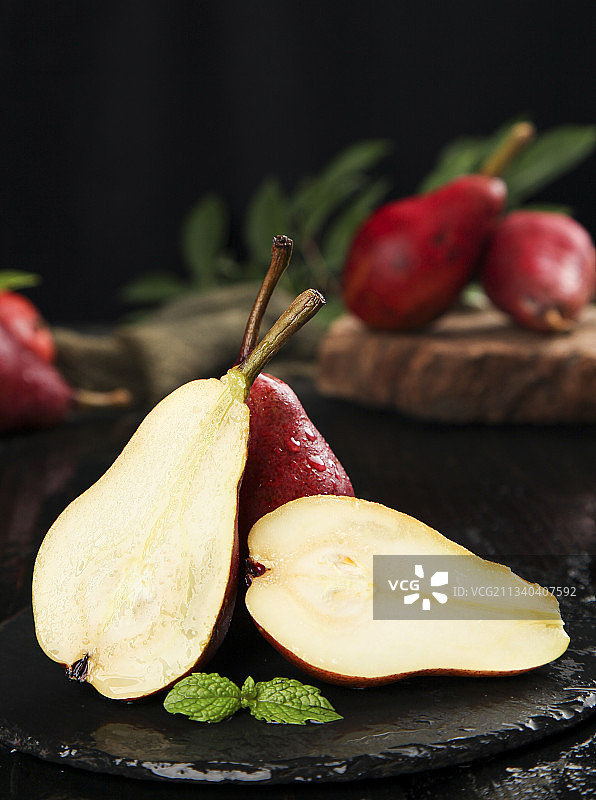 黑底上放着切开的红啤梨图片素材