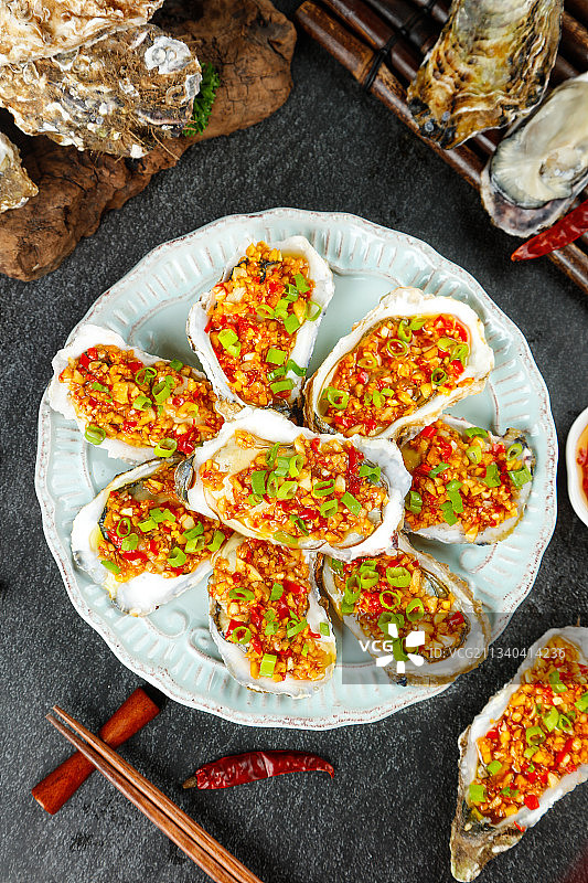深底上放着一盘香辣烤生蚝图片素材