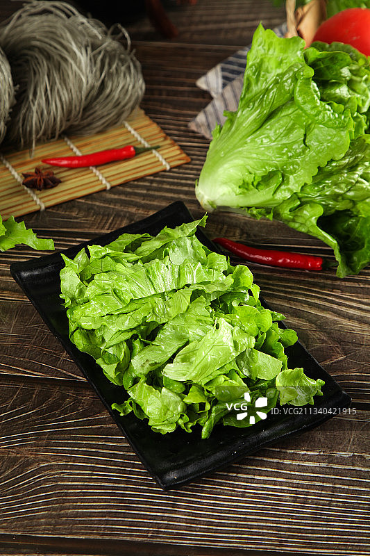 一盘切开的包心生菜放在木底上图片素材