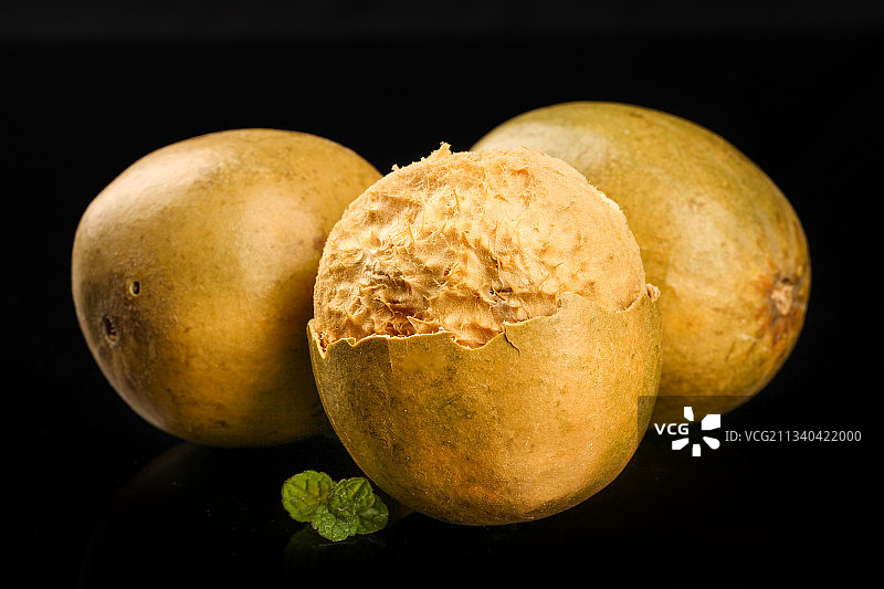 剥开的广西罗汉果放在黑底上图片素材