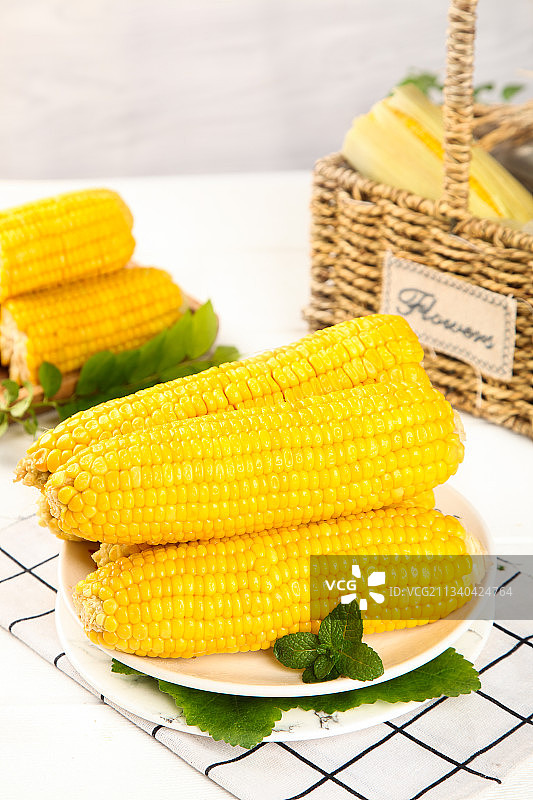 白格子底上放着一盘甜玉米图片素材