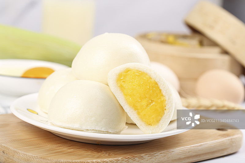 木板上放着奶黄馅包子图片素材