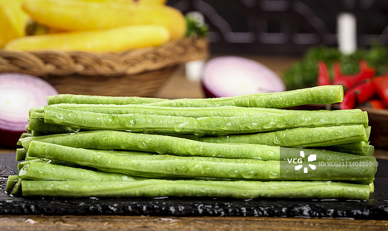 木板上放着一盘新鲜豆角图片素材