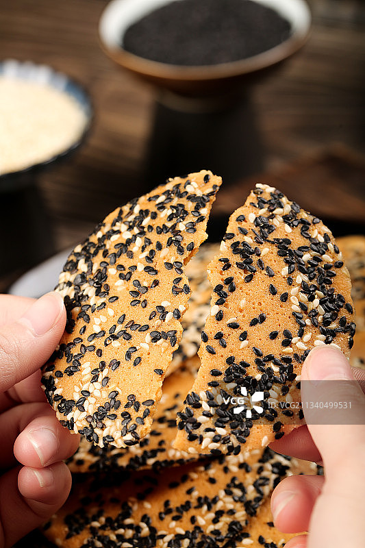 手里拿着芝麻薄脆饼图片素材