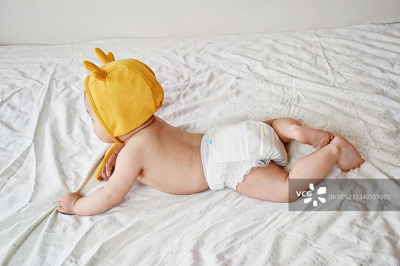 可爱的婴儿宝宝趴在床上图片素材