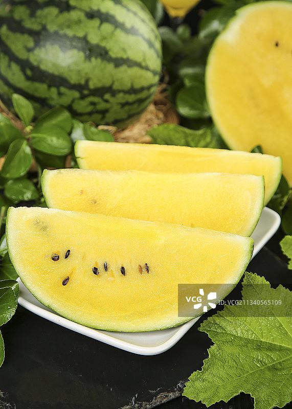 深底上放着切开的黄瓤西瓜图片素材