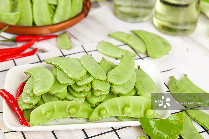 格子底上摆放着扁豆角图片素材