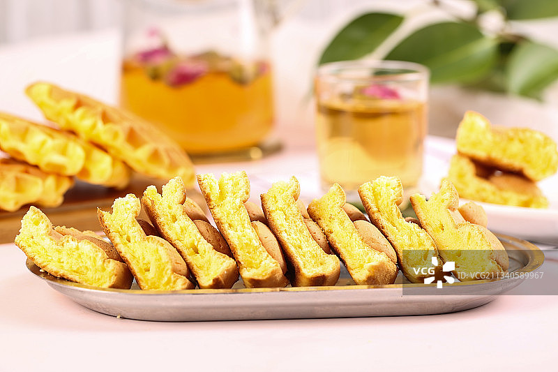 浅底上放着一盘掰开的鸡蛋仔蛋糕图片素材