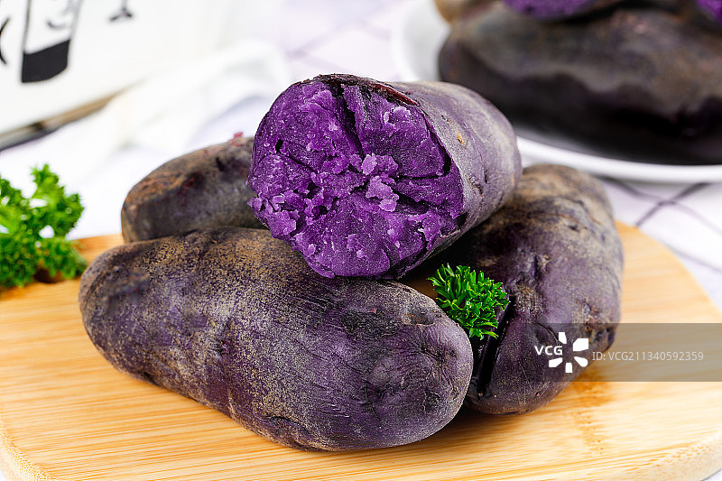 木板上的黑皮紫心土豆图片素材