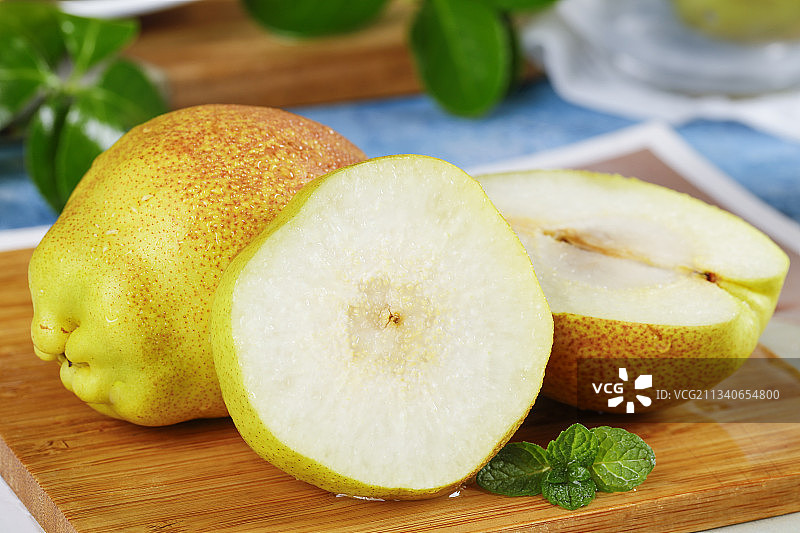 切开的新鲜小香梨放在木底上图片素材