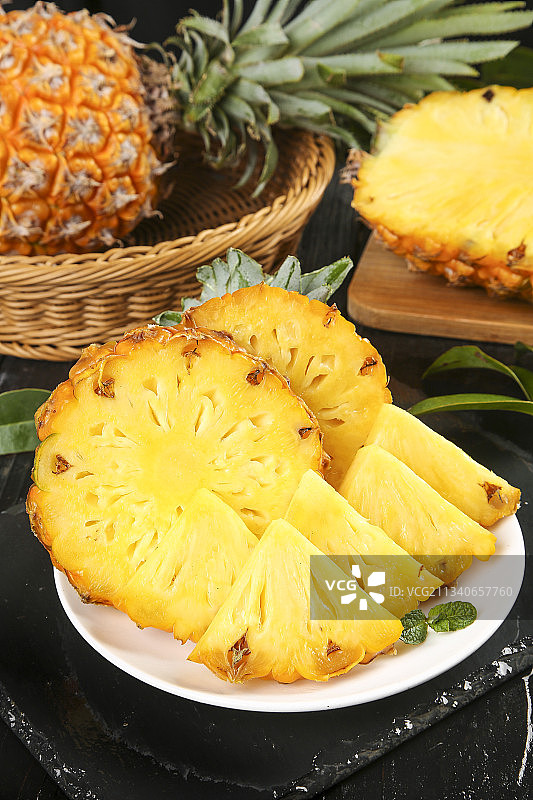 黑石板上放着一盘切开的徐闻菠萝图片素材