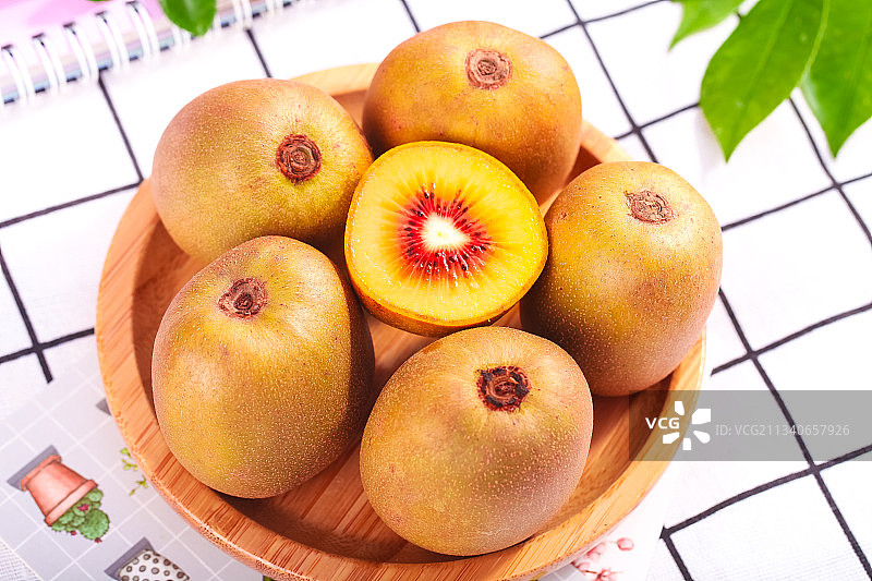 木碟上放着切开的四川红心猕猴桃图片素材