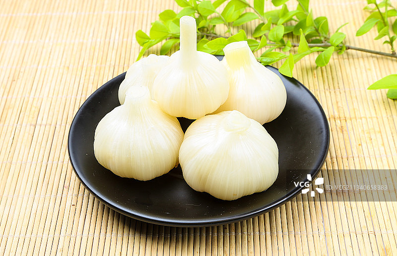 一盘泡蒜放在木底上图片素材
