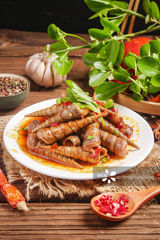 木底上放着一盘香辣钉螺图片素材