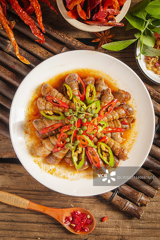 木底上放着一盘香辣钉螺图片素材