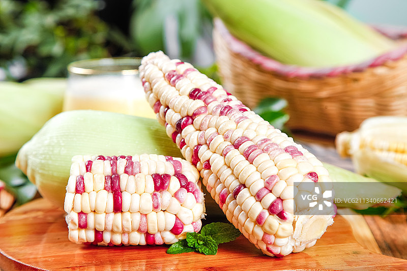 木板上放着剥皮的花糯玉米图片素材