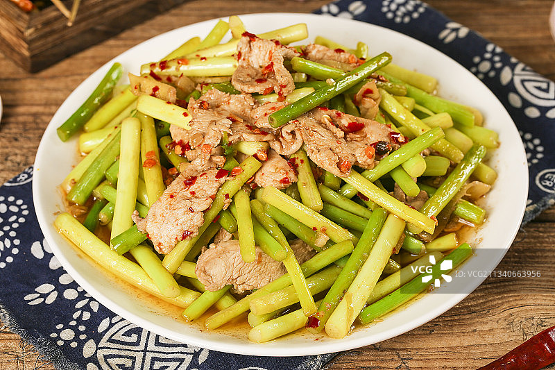 木板上放着一盘蒜苔炒肉图片素材