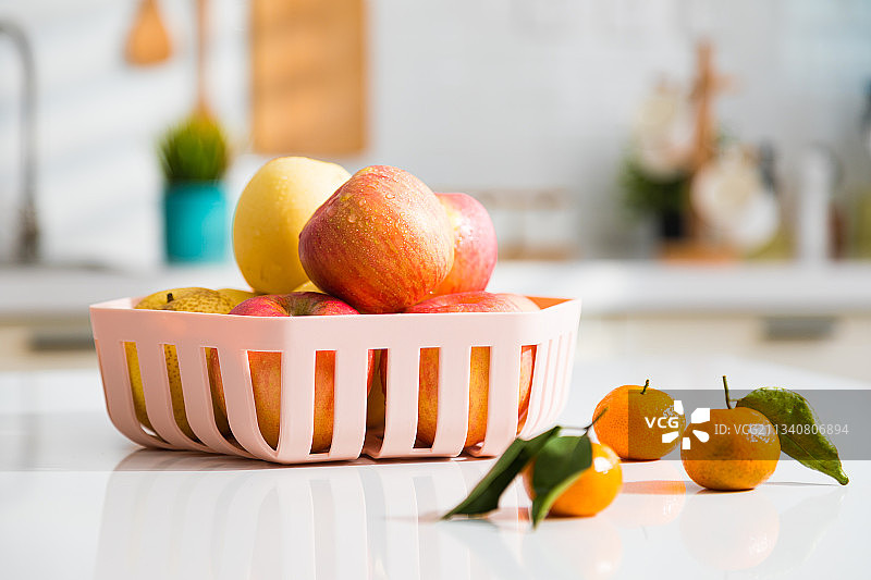 彩纸上的彩色塑料水果篮洗菜篮沥水篮图片素材