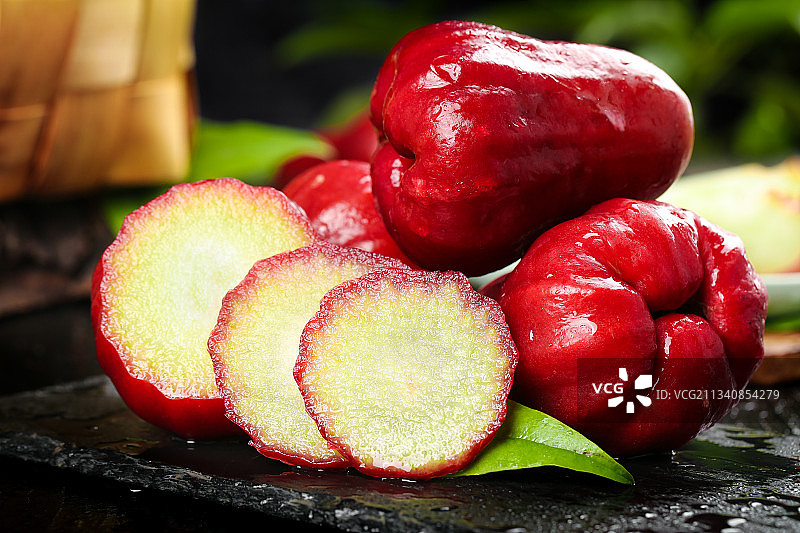 黑底上放着切开的莲雾图片素材