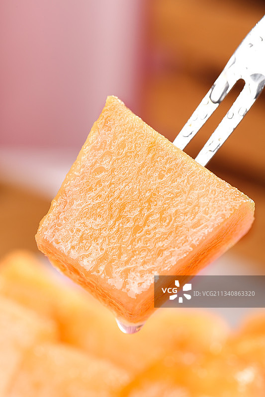 叉子叉着一块新鲜哈密瓜图片素材