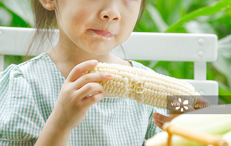 小女孩正在吃牛奶水果玉米图片素材