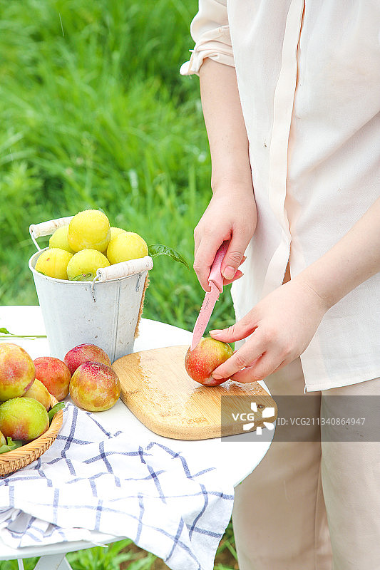 木板上放着正在切的桃形李图片素材