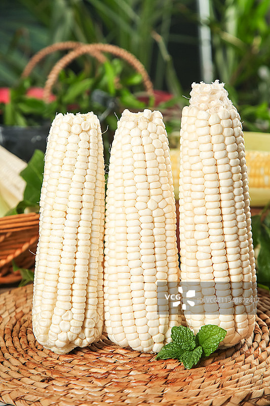 编织垫上放着甜玉米图片素材