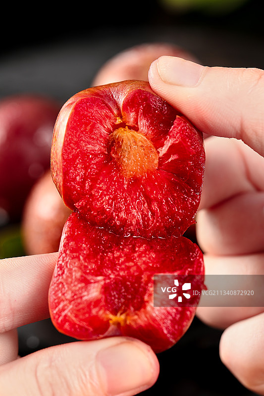 手里拿着红心李图片素材