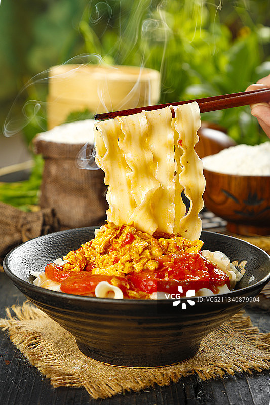 木底上放着一碗西红柿鸡蛋刀削面图片素材