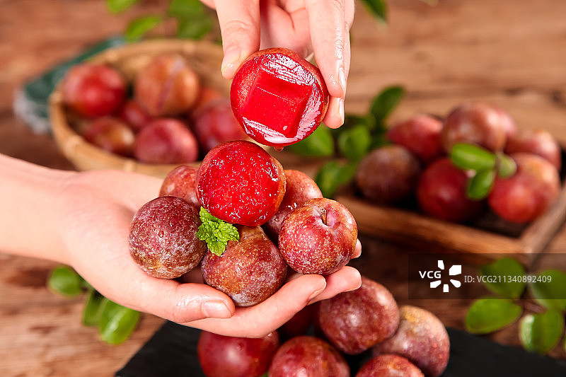 手里拿着红心三华李图片素材