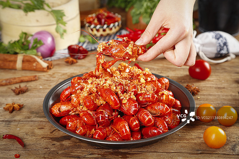 手里端着一盆蒜蓉小龙虾图片素材