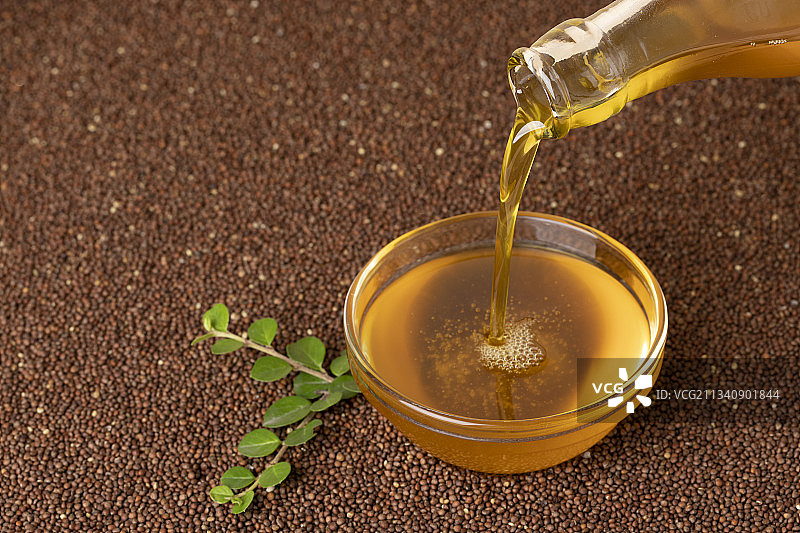 玻璃碗中倒入紫苏油，紫苏籽背景图片素材
