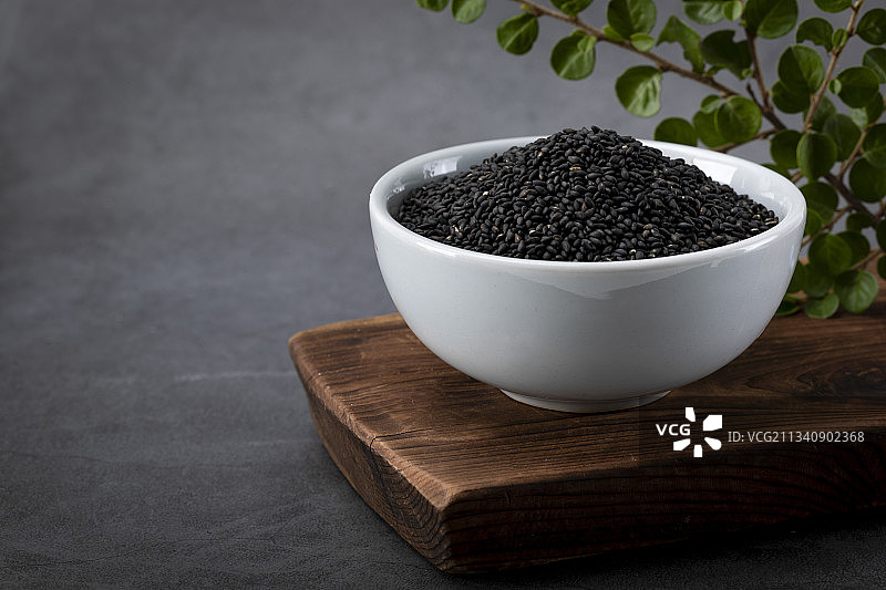 木板上瓷碗里的紫苏籽图片素材