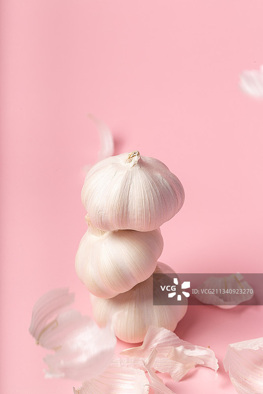 粉色背景重叠大蒜散落的大蒜皮静物图片素材