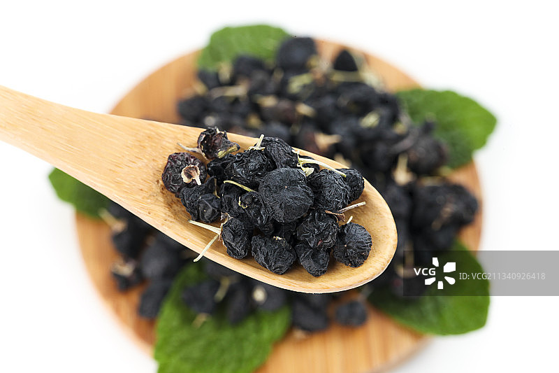 勺子上放着野生黑枸杞图片素材