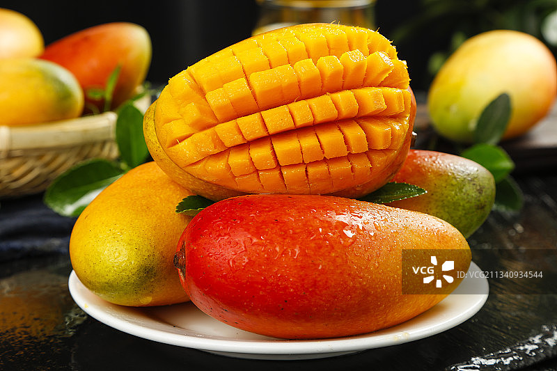 黑底上放着一盘新鲜贵妃芒果图片素材
